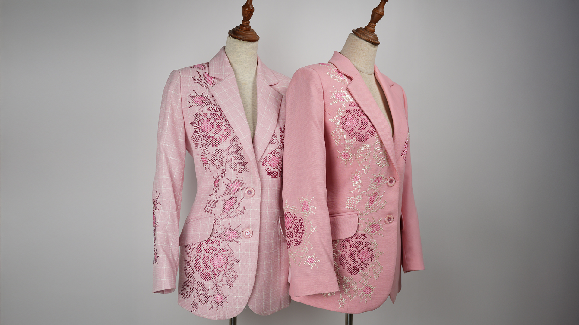 Two pink blazers with cross-stitch floral embroidery on mannequins